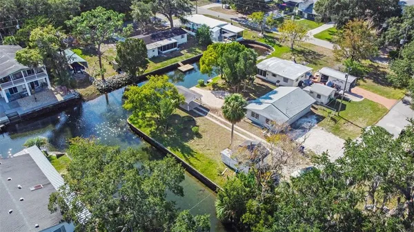 an aerial view of residential houses with outdoor space and trees