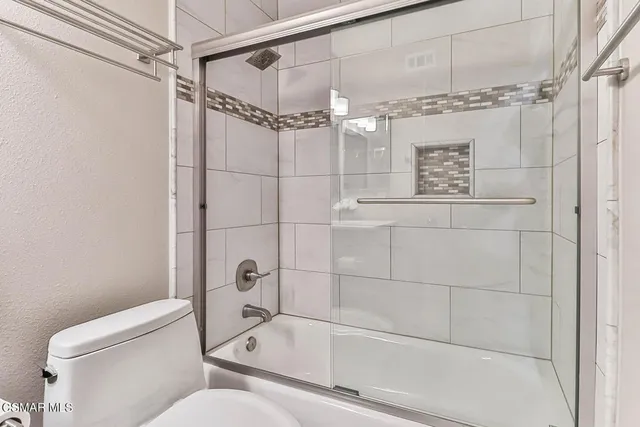 a large bed sitting in a bedroom next to a window