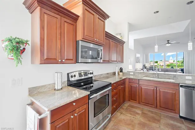 a kitchen with stainless steel appliances granite countertop a sink stove and microwave