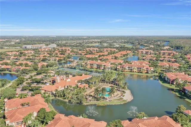 an aerial view of residential houses with outdoor space and lake view in back
