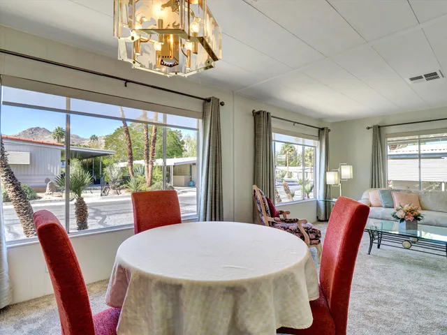 a view of a dining room with furniture a chandelier and window