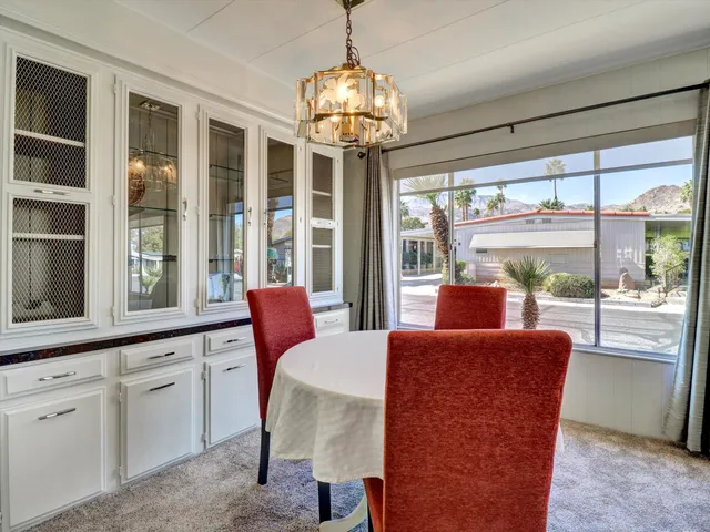 a view of a dining room with furniture large windows and wooden floor