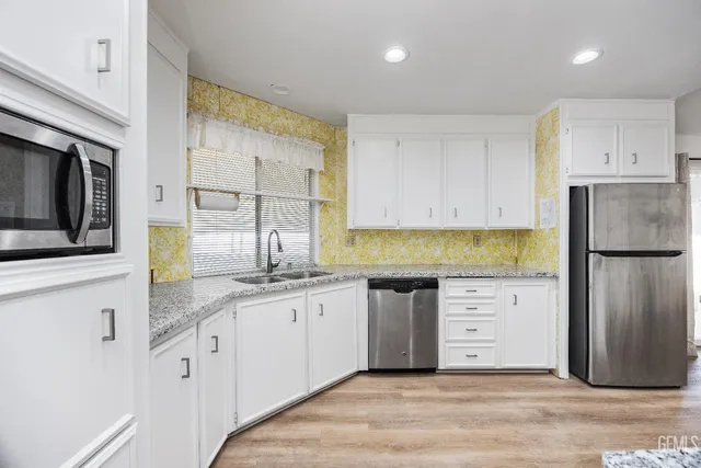 a kitchen with stainless steel appliances granite countertop a stove a refrigerator and a granite counter tops