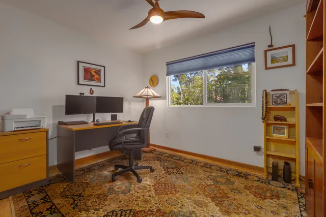 a view of a workspace with furniture and a window