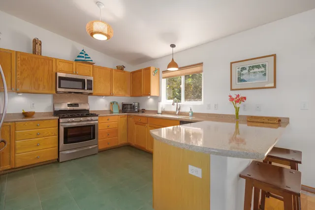 a kitchen with stainless steel appliances granite countertop a sink a stove and a refrigerator