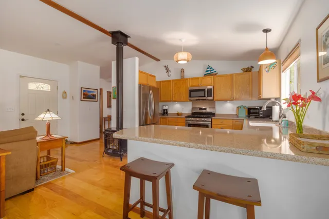 a kitchen with stainless steel appliances granite countertop a sink a stove and a refrigerator