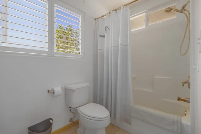 a white toilet sitting next to a bath tub shower