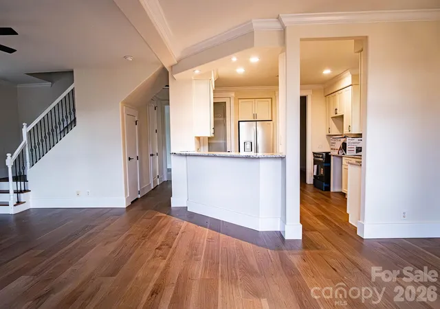 a kitchen with a sink wooden floor and stainless steel appliances