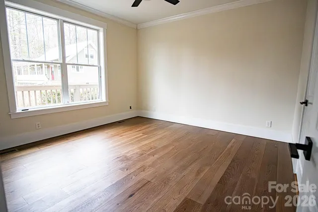 a view of empty room with wooden floor