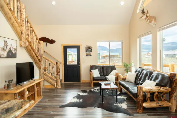 a living room with furniture a flat screen tv and a floor to ceiling window