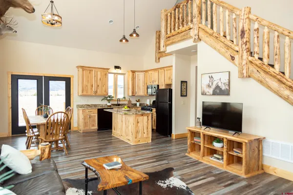 a living room with furniture a flat screen tv and wooden floor