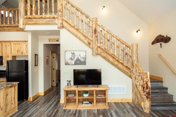 a living room with wooden floor and a flat screen tv