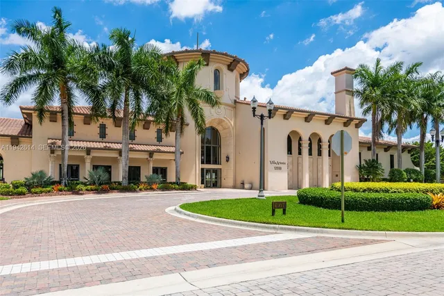front view of house with a yard and palm trees