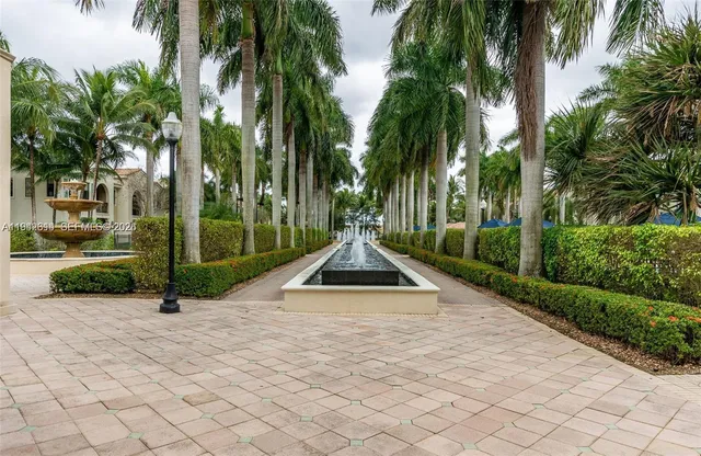 a view of a house with a yard and potted plants