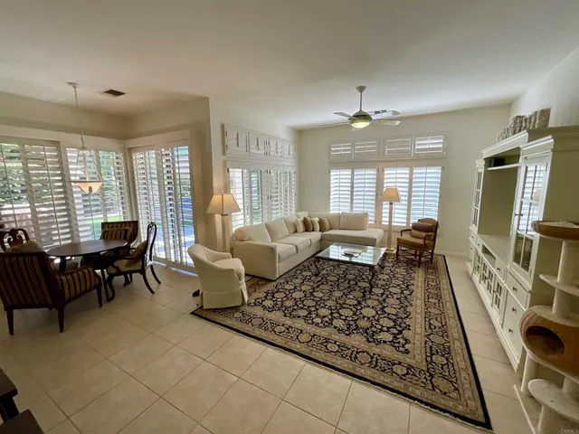 a living room with furniture a flat screen tv and a large window