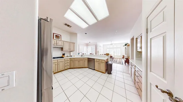 a large white kitchen with a sink and dishwasher a refrigerator with white cabinets