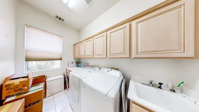 a utility room with cabinets washer and dryer