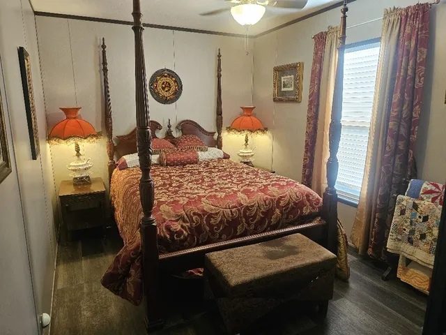 a bedroom with a bed a clock on the wall and dresser
