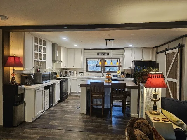 a kitchen with stainless steel appliances wooden floor and refrigerator