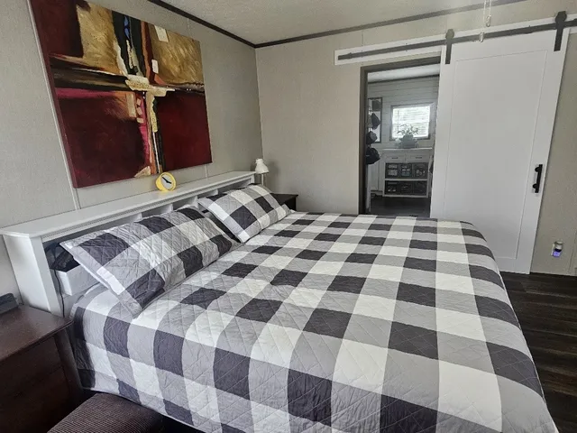 a bedroom with a bed and a black mirror