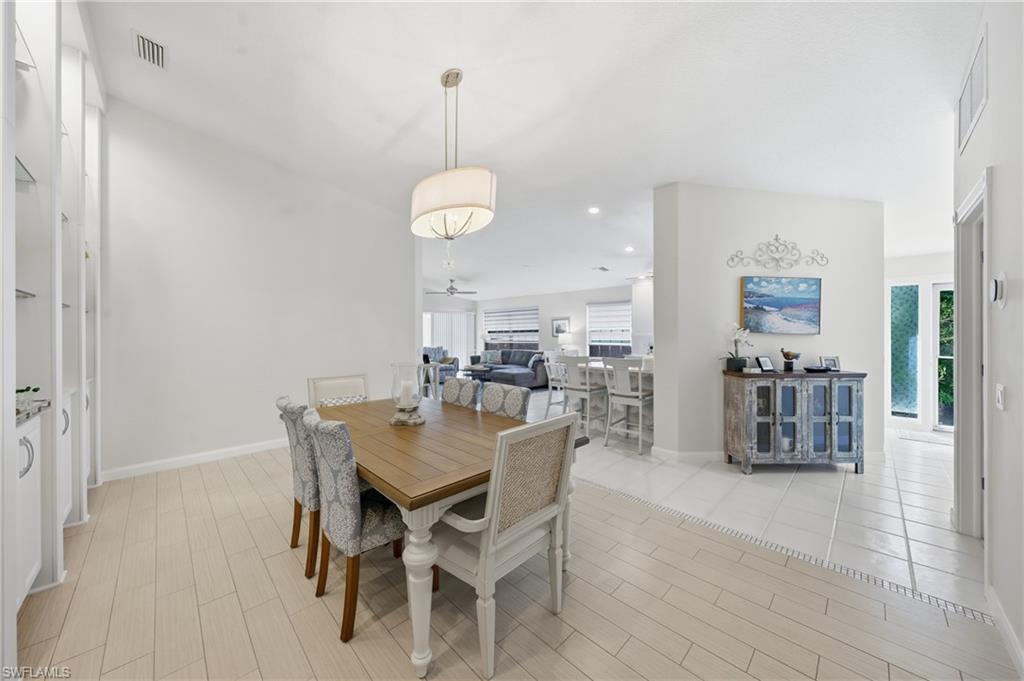3614 El Segundo Court Naples, FL 34109 - Photo 8 of 49 a view of a dining room and livingroom with furniture wooden floor a chandelier