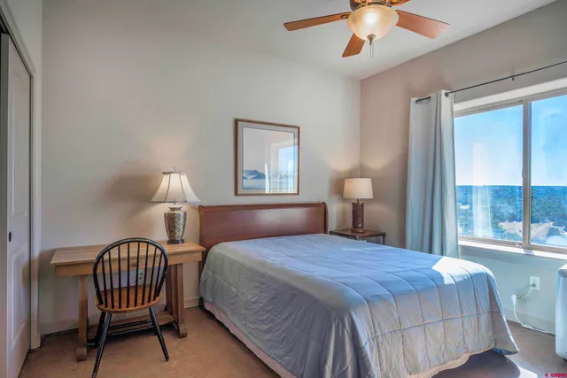 a bedroom with a bed desk and a window