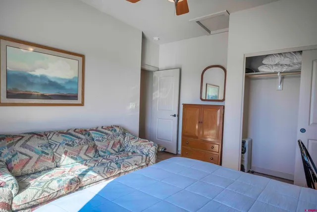 a bedroom with a bed and a painting on the wall