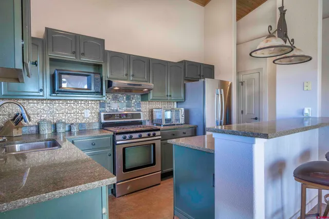 a kitchen with stainless steel appliances granite countertop a stove and a refrigerator