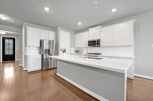 a kitchen with refrigerator cabinets and wooden floor