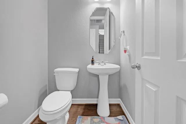 a bathroom with a sink toilet and a mirror