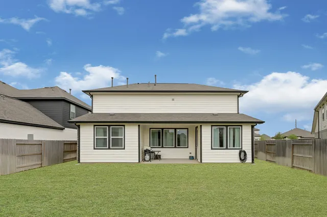 a view of house with yard and balcony