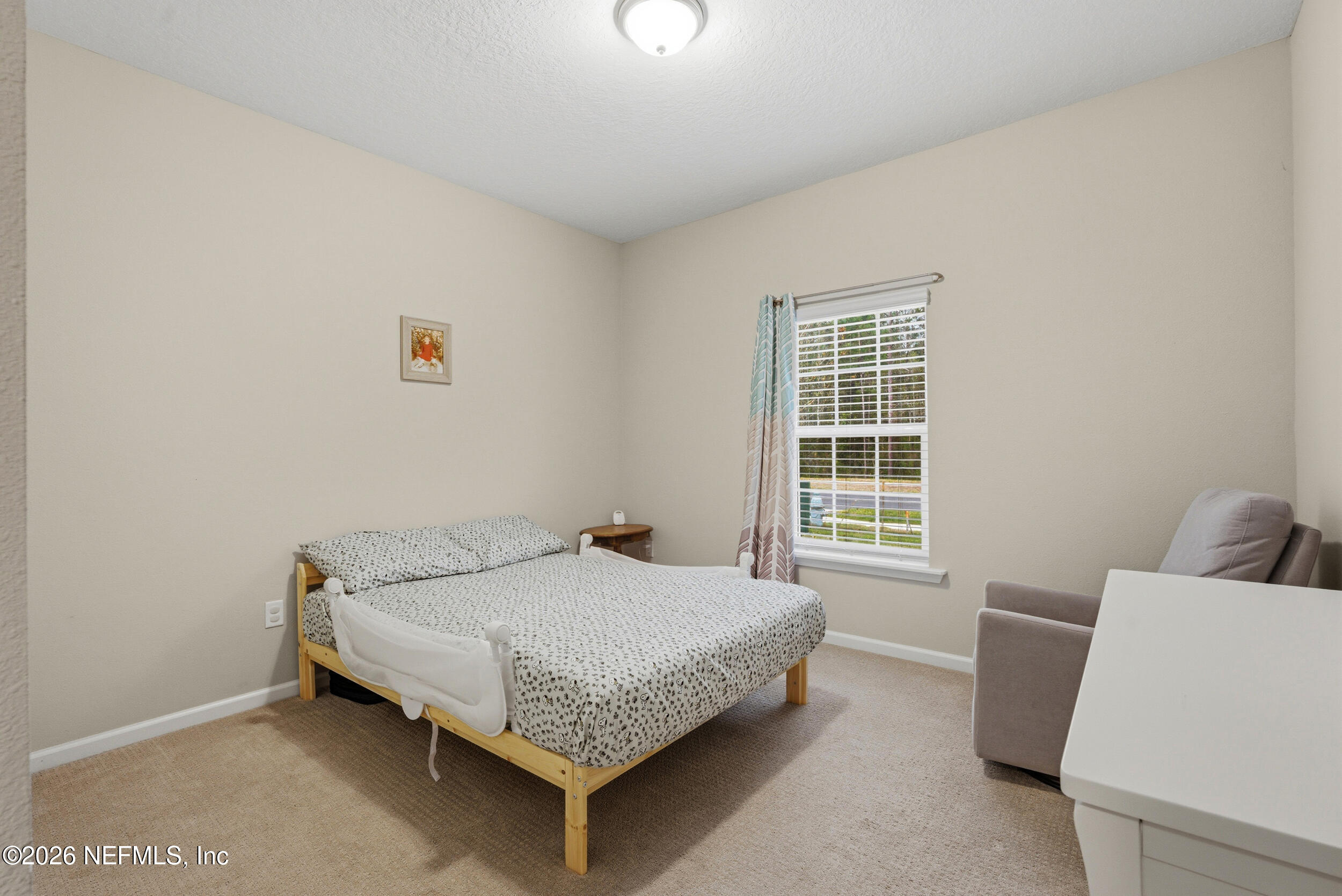 635 Sycamore Way Orange Park, FL 32073 - Photo 21 of 42 a bedroom with a bed and a table in it with window