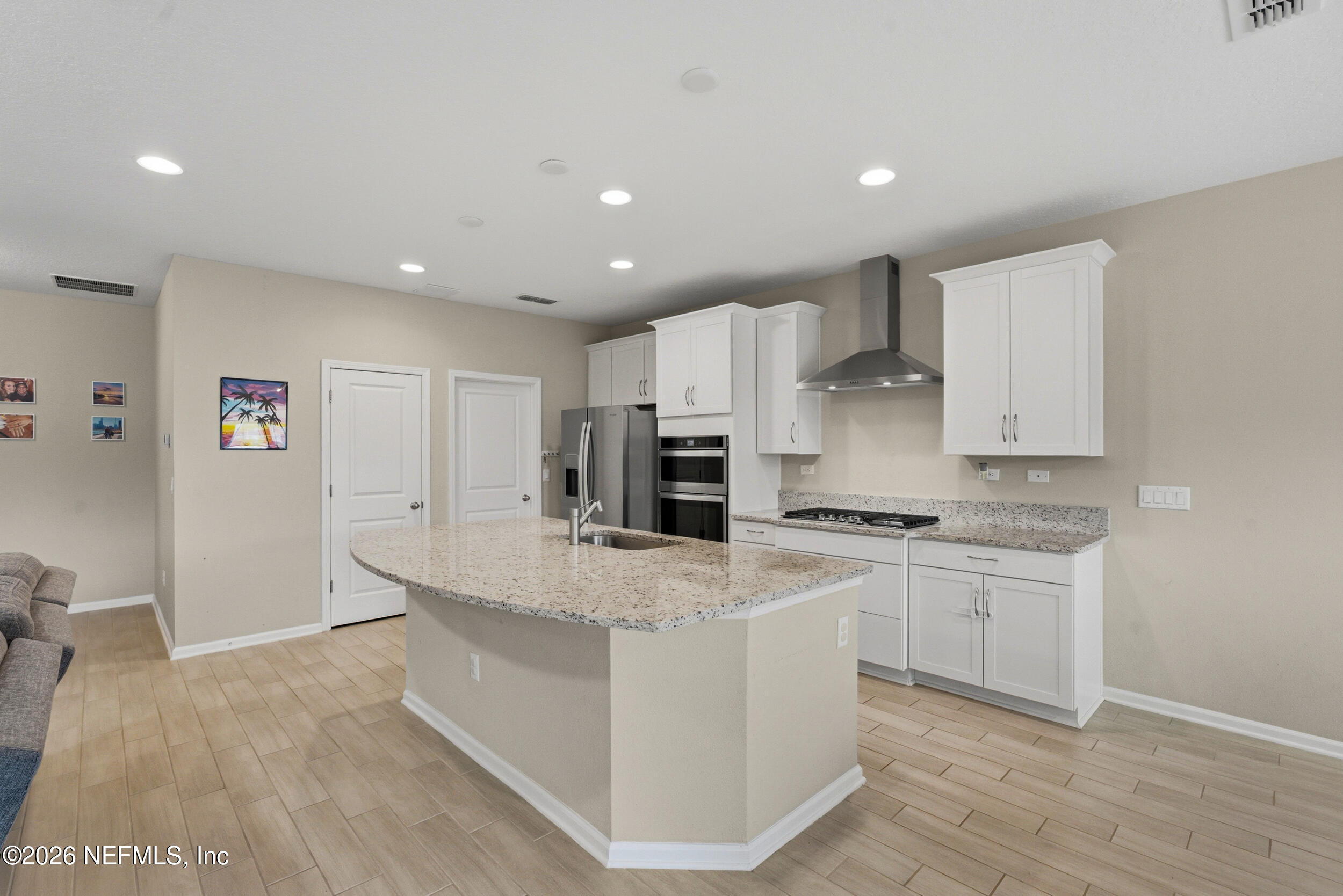 635 Sycamore Way Orange Park, FL 32073 - Photo 8 of 42 a large kitchen with stainless steel appliances granite countertop a stove a sink a refrigerator and white cabinets with wooden floor