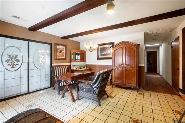 a living room with furniture a chandelier and a dining table