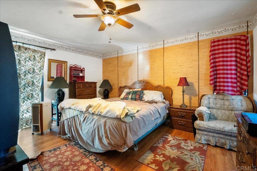 823 Rice Canyon Road Fallbrook, CA 92028 - Photo 21 of 31 a bedroom with a bed and wooden floor