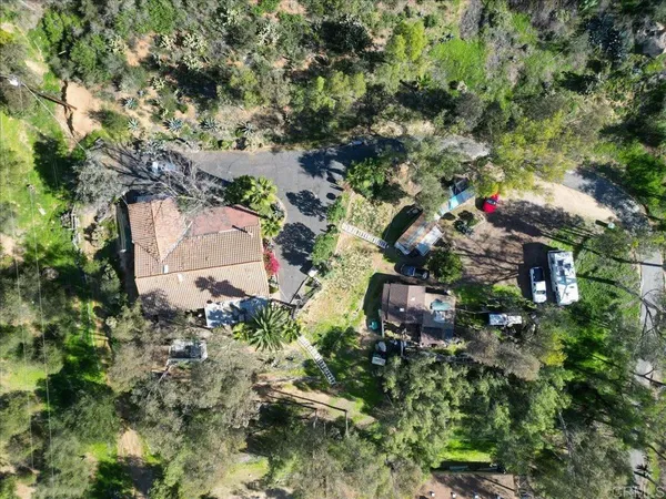 an aerial view of residential house with outdoor space and trees all around