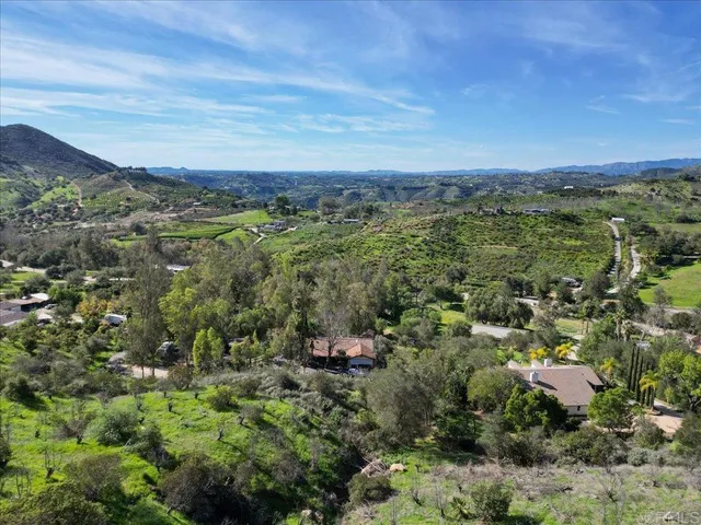 an aerial view of a city with lots of residential buildings and mountain view in back