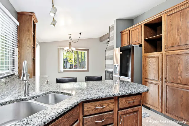 a kitchen with granite countertop a sink and a refrigerator