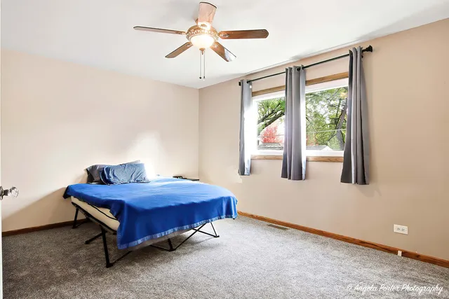 a room with a bed and a chandelier fan