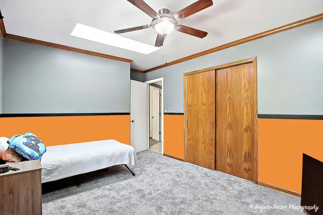 a bedroom with a bed and a chandelier fan