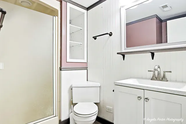 a bathroom with a toilet a sink and a mirror