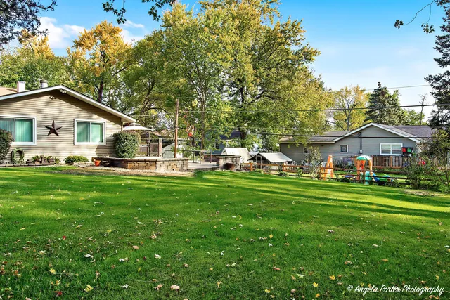 a front view of a house with a garden and trees