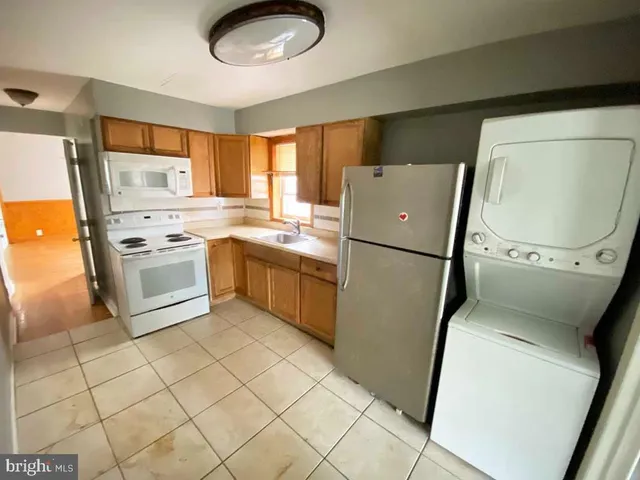 a kitchen with a refrigerator sink and cabinets