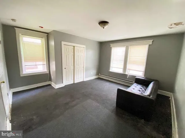 a view of an empty room with a window and a couch
