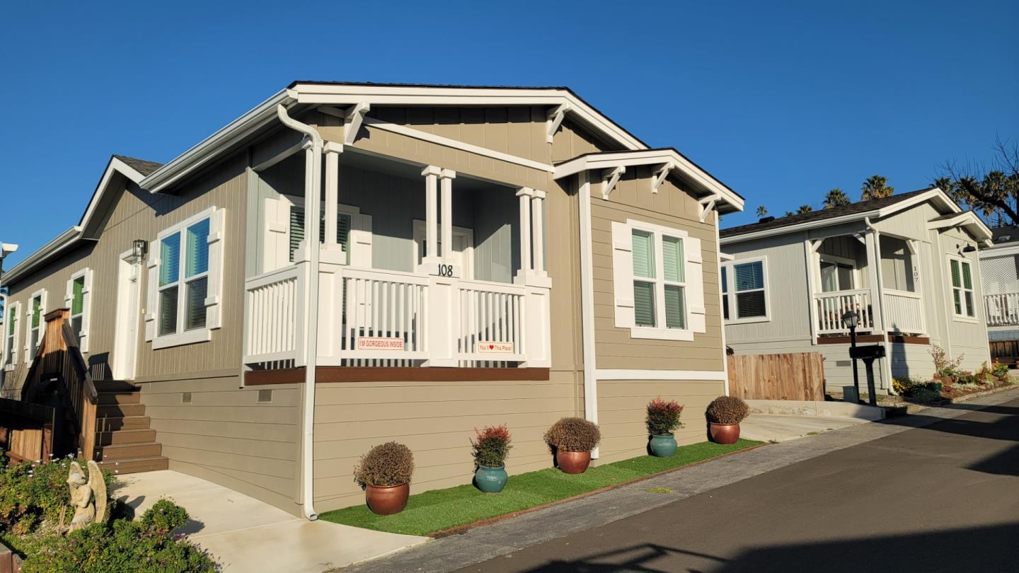a view of a white house with large windows and a table and chairs