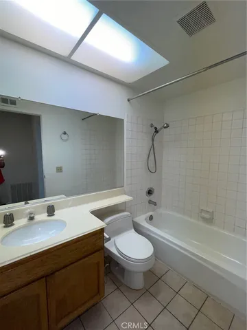 a bathroom with a granite countertop sink a toilet and shower