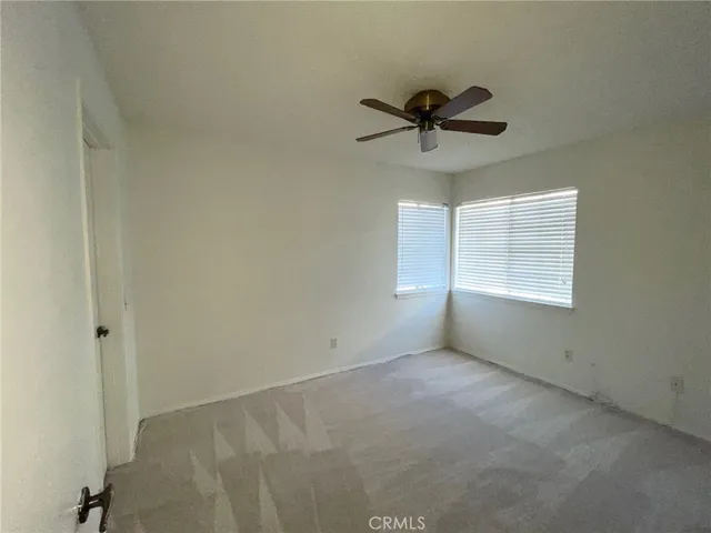 a view of a room with a ceiling fan and window