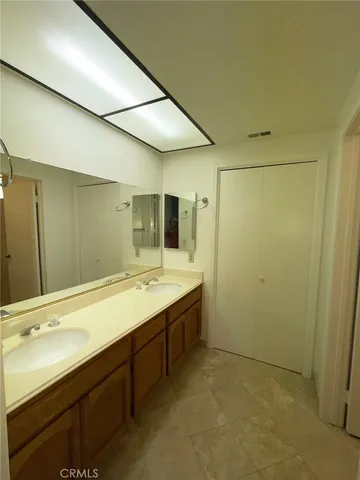 a bathroom with a double vanity sink and mirror