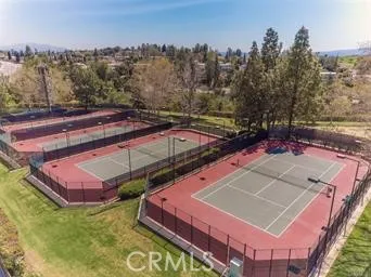 a view of a tennis ground with large trees
