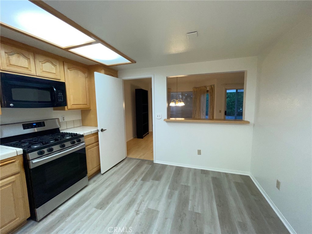 19500 Crystal Ridge Lane Porter Ranch, CA 91326 - Photo 6 of 33 a kitchen with wooden floors and a stove top oven